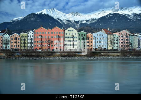 Die österreichischen Alpen hinter dem Fluss "Inn" und bunten Häusern. Dieses Foto wurde in Innsbruck übernommen. Stockfoto
