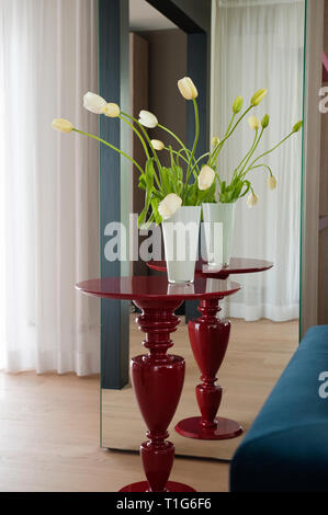 Vase mit Tulpen auf den Tisch mit Spiegel Stockfoto