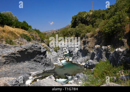 Alcantara Schlucht (Gole dell Alcantara), Sizilien, Italien. Farbenfrohe Natur Landschaft, Strom fließt durch Basaltlava Feld anhand klarer, blauer Himmel Stockfoto