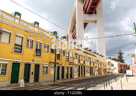 Ruhige Wohnstraße direkt unterhalb der Zugang zum 25. April Suspension Bridge in Lissabon, Portugal Stockfoto