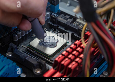 Ingenieur die Wärmeleitpaste auf dem Computer Board chip cpu Stockfoto