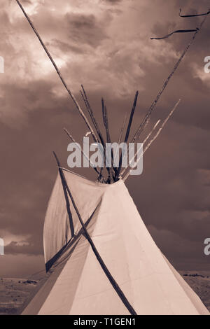 Eine Nahaufnahme bei Sonnenuntergang von der oberen Hälfte von einem Tipi mit dramatischen Himmel in der Western Plains in coppertoned Stockfoto