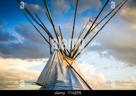 Ein 7/8-Nahaufnahme der oben in einem Tipi mit dramatischen Himmel in der Western Plains bei Sonnenuntergang in den USA Stockfoto