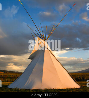 Blick auf ein Tipi mit dramatischen Himmel in der Western Plains bei Sonnenuntergang in den USA Stockfoto