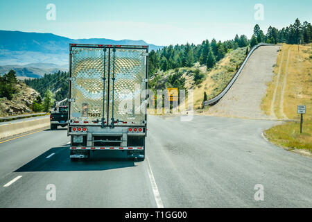 Ein Big Rig Truck bergab neben einem leeren runaway Lkw-Rampe auf einen steilen Hang von der Interstate I-90 Highway in Montana, USA Stockfoto