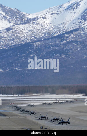 F-22 Raptors aus der 3 Flügel und 477th Fighter Group beteiligen sich in einer engen Formation Taxi, bekannt als ein Elephant Walk, 26. März 2019, während eines Polar Kraft Übung in Joint Base Elmendorf-Richardson, Alaska. Dieser zweiwöchige Übung gibt staffeln die Möglichkeit, ihre Fähigkeiten unter Beweis zu stellen, Bereitstellen und liefern überwältigende bekämpfen Airpower. (U.S. Air Force Foto von Justin Connaher) Stockfoto