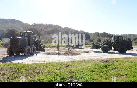 190312-N-MW 964-1066 Vandenberg Air Force Base, Calif (Mar. 12, 2019) - seabees zu Naval Mobile Konstruktion Bataillon 5 zugeordnet, Rückstände mit einem 924 Cat Radlader Kompaktlader entfernen und einen CAT Grader in einer Expeditionary schnelle Flugplatz Schäden reparieren (ExRADR) Übung auf der Vandenberg Air Force Base in Unterstützung der Übung Pacific Blitz 2019 (PacBlitz 19). ExRADR tests Seabee Einheiten' Fähigkeit, Start- und Landebahnen, die weitere Unterstützung des Navy und Marine Corps Operationen zu reparieren. Marine Expeditionary Kräfte unterstützen die Marine Expeditionary Kräfte und der Flotte durch die Einführung theater Logistik durch die devel Stockfoto