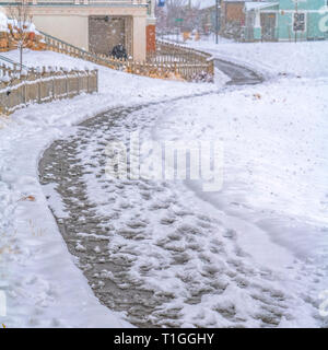 Gewundene Weg entlang der schneebedeckten Boden in Daybreak. Nahaufnahme von einem schmalen kurvigen Weg auf schneebedeckten Boden im Winter und vorbei vor der Schnee Stockfoto
