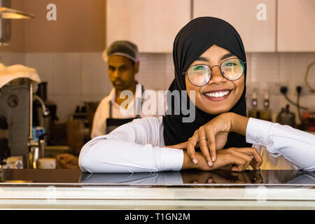 Male, Malediven - 11. Februar 2019: Porträt einer muslimischen Frau, tragen, Hijab und Brillen wer arbeitet als Kellnerin in einem Coffee Shop in Male, Malediven Stockfoto