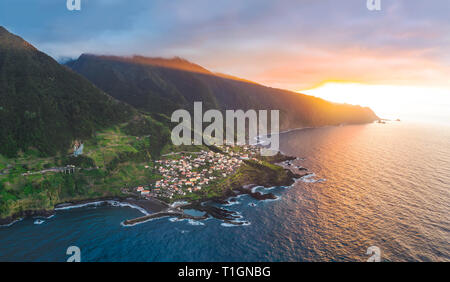 Luftaufnahme von Sexial gefärbt durch den Sonnenuntergang, wo das Land den Ozean trifft, an der Nordküste der Insel Madeira, Portugal Stockfoto