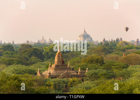 Ein unbekannter Burmesischen Paar, tragen eine traditionelle Longyi, nehmen Fotos und selfies vom Dach eines der vielen Tempel in Bagan. Stockfoto