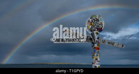 Regenbogen über dem John O Groats Wegweiser, Caithness, Highlands, Schottland, UK Stockfoto