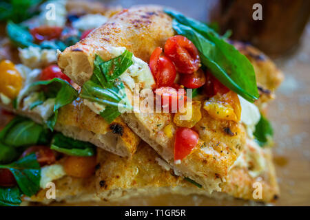 Scheiben von bunten römischen Stil italienische Holzofen Pizza mit Tomaten und Basilikum, mozzerella Stockfoto