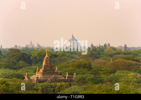 Ein unbekannter Burmesischen Paar, tragen eine traditionelle Longyi, nehmen Fotos und selfies vom Dach eines der vielen Tempel in Bagan. Stockfoto