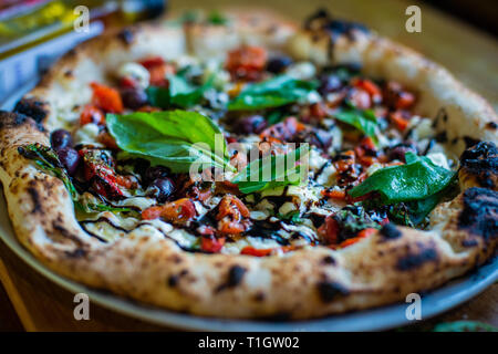 Authentische italienische neapolitanischen Stil Holzofen Pizza auf der Tabelle in einer Pizzeria Trattoria Restaurant Stockfoto