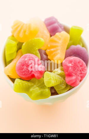 Grütze Bonbons in Schüssel auf farbigen Hintergrund. Stockfoto