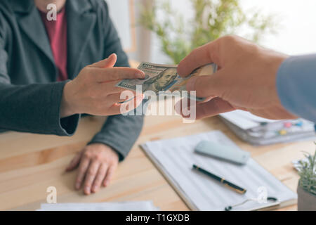 Schweigegeld, Bestechung und Korruption, Mann mit Bargeld 100 US Dollar Papier Währung Rechnung zu weiblichen Geschäft Person Stockfoto