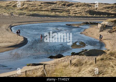 Ferner Zahlen über die Afon Crigyll Fluss waten, Rhosneigr, Anglesey, North Wales, UK Stockfoto