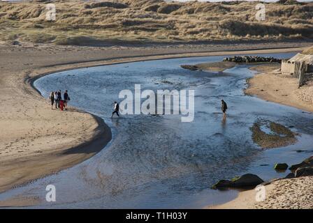 Ferner Zahlen über die Afon Crigyll Fluss waten, Rhosneigr, Anglesey, North Wales, UK Stockfoto