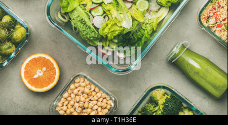 Gesunde vegane Gerichte in Glasbehältern. Flachbild-lay von Gemüse Salate, Hülsenfrüchte, Bohnen, Rosenkohl, Hummus und frische Säfte in Flaschen über konkrete Tabl Stockfoto