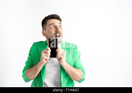 Sein kühles. Gute Nachrichten. Tun, wie mich. Jungen gutaussehenden Mann zeigt der Bildschirm des Smartphones und Unterzeichnung OK Zeichen auf grauem Hintergrund. Menschliche Emotionen, Fa Stockfoto