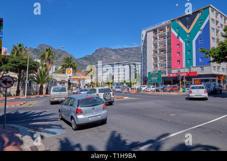 Street im Stadtzentrum von Kapstadt, mit Autos vorbei, Tafelberg im Hintergrund, und Apartment Gebäude in Farbe der Flagge. Kapstadt, Südafrika, Stockfoto