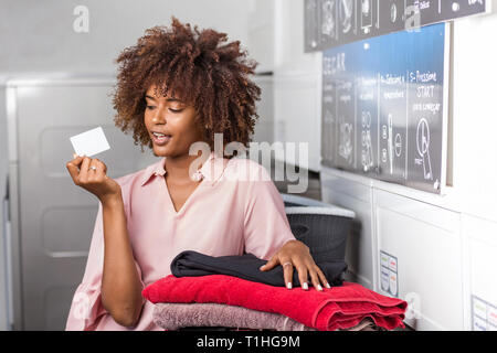 Junge schwarze afrikanische amerikanische Frau mit einem Wäscheservice Abonnement Stockfoto