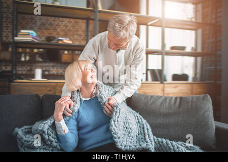 Portrait Of Happy senior Paar zu Hause. Sie sitzt auf dem Stockfoto