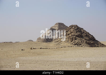 Sakkara, Ägypten: Die Pyramide des Userkaf (rechts) mit der stufenpyramide des Djoser, die sich einer Restaurierung, im Hintergrund. Stockfoto