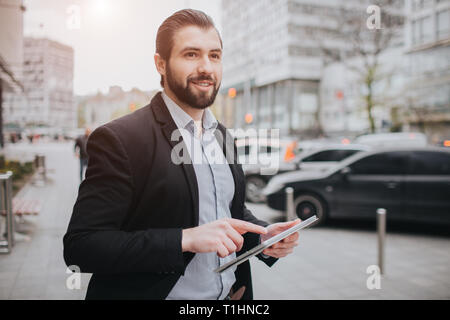 Viel beschäftigter Mann ist in Eile, hat er keine Zeit, er wird Tablet-PC auf die Go zu verwenden. Unternehmer dabei mehrere Aufgaben. Multitasking business Person. Stockfoto