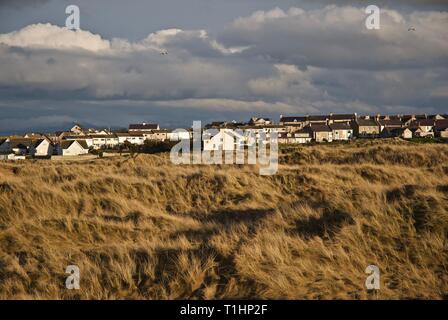 Dorf Eigenschaften betrachtet aus durch die Dünen von trewan Gemeinsame, Rhosneigr, Anglesey, North Wales, UK Stockfoto