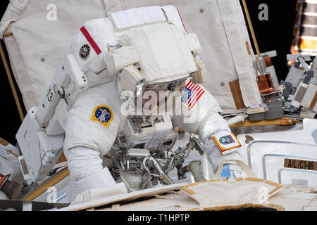 Expedition 59 NASA-Astronauten Anne McClain funktioniert die Stromversorgung während der Aktualisierung ein spacewalk außerhalb der internationalen Raumstation März 22, 2019 im Erdorbit. Astronauten McClain und Haag 6-Stunden- und 39-Minuten außerhalb der Raumstation power Speicherkapazität der orbital Komplex zu aktualisieren. Stockfoto