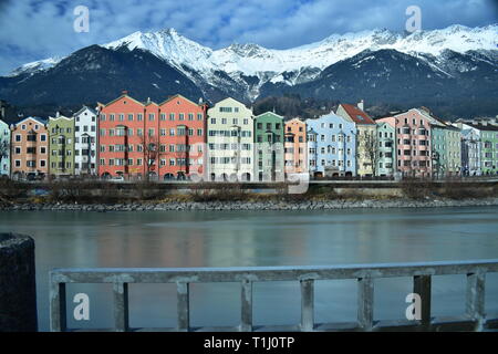 Die österreichischen Alpen hinter dem Fluss "Inn" und bunten Häusern. Dieses Foto wurde in Innsbruck übernommen. Stockfoto