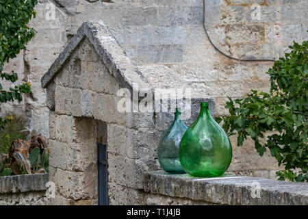 Zwei riesige grüne Glas leer Wein Gläser in einer Zeile platziert, die die beeindruckende Architektur von Matera, Basilikata, Italien und die Moody bewölkt Summe Stockfoto