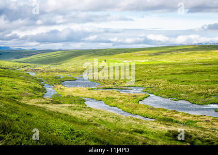 Querformat von Island wiese feld in der Nähe von Skutustadagigar und See Myvatn während bewölkt sonniger Tag und grünes Gras mit Fluss im Sommer und Haus Stockfoto