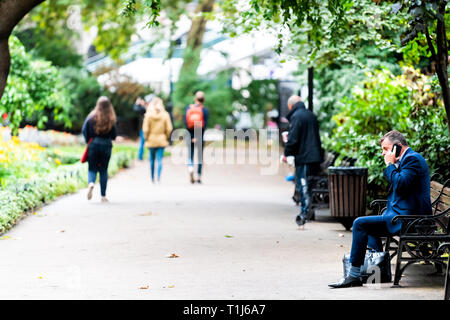 London, Großbritannien - 12 September, 2018: die Menschen zu Fuß in Whitehall Gardens von Thames River Victoria Embankment in Westminster sitzt auf der Bank Stockfoto