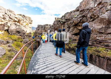 Thingvellir, Island - 20. September 2018: Nationalpark Menschen zu Fuß auf boardwalk Trail Canyon Wasserscheide Platte während Tag Landschaft Stockfoto