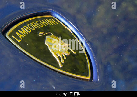 Lamborghini logo schließen bis auf ein blaues Auto mit der Sonne aus. Stockfoto