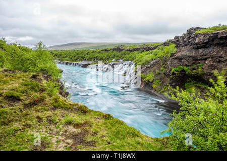 Lange Belichtung glatte Bunte vibrant Blue aqua Türkis Wasser Wasserfall Wasserfälle Hraunfossar Lava in Island, Querformat Stockfoto