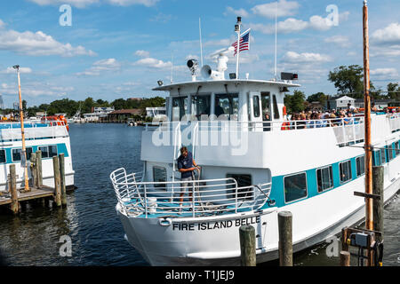 Bay Shore, New York, USA - 25. August 2018: Das Feuer Insel Belle Fähre verlassen der Bay Shore Docks, Menschen im Urlaub und am Strand Stockfoto