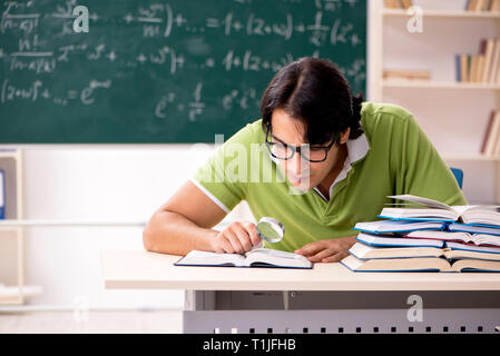 Gut aussehender Student vor der Tafel mit Formeln Stockfoto