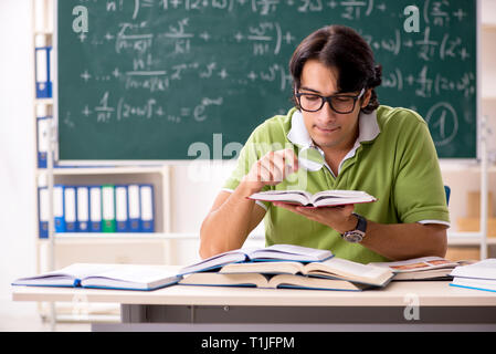 Gut aussehender Student vor der Tafel mit Formeln Stockfoto