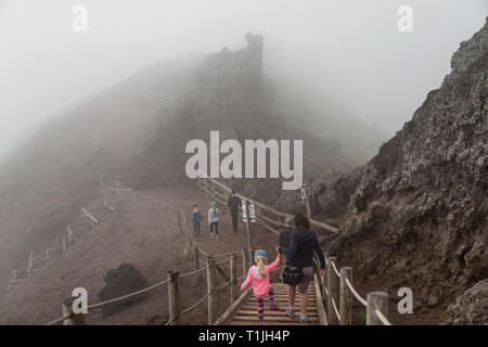 Den Vesuv, Neapel, Italien - 24. Mai 2018: Menschen, Erwachsene und Kinder Wandern rund um den Krater. Weg mit dem Sicherungsseil auf dem Wanderweg. Stockfoto