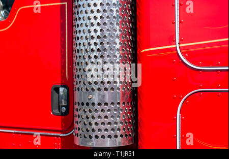 Die Seite von professionellen Industrial Grade cab und Wand der klassischen Big Rig rot Sauber Glänzend Semi Truck auf Parkplatz in der Nähe der Lager geparkt warten Stockfoto