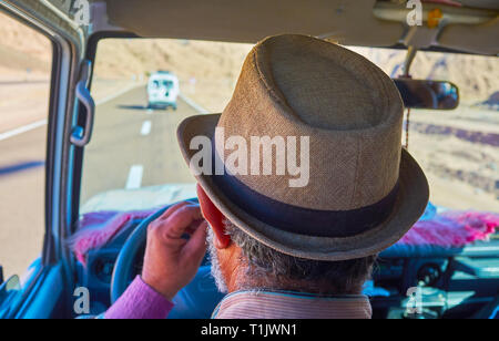 Die älteren Ägyptischen im Stroh Hut fährt das Auto entlang der Wüste Straße, Sinai, Ägypten. Stockfoto