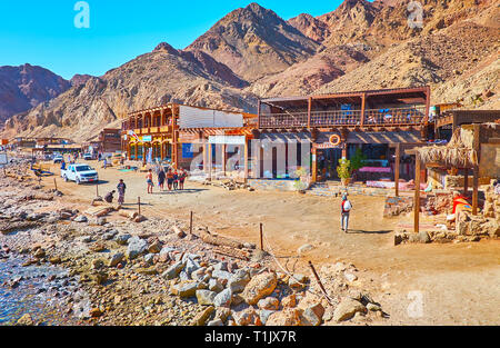 DAHAB, Ägypten - Dezember 16, 2017: Die Linie der restautants vor der Wüste Felsen am Ufer des Blue Hole Schnorcheln, beliebt bei den Touristen, Stockfoto