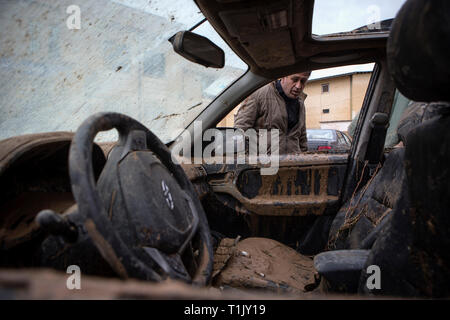 Shiraz, Iran. 26 Mär, 2019. Ein Mann betrachtet ein beschädigtes Fahrzeug nach einer Flut von starken Regenfällen in Schiraz, Iran, 26. März 2019 verursacht. Mindestens 25 Menschen wurden bei dem starken Regen und der anschließenden Überschwemmungen im Iran in der vergangenen Woche getötet. Credit: Ahmad Halabisaz/Xinhua/Alamy leben Nachrichten Stockfoto