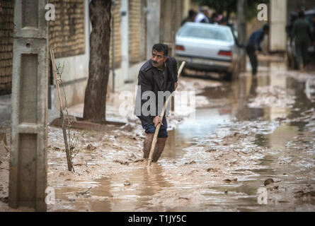 Shiraz, Iran. 26 Mär, 2019. Ein Mann Beseitigt Schlamm nach einer Flut von starken Regenfällen in Schiraz, Iran, 26. März 2019 verursacht. Mindestens 25 Menschen wurden bei dem starken Regen und der anschließenden Überschwemmungen im Iran in der vergangenen Woche getötet. Credit: Ahmad Halabisaz/Xinhua/Alamy leben Nachrichten Stockfoto