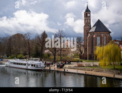 Brandenburg an der Havel, Deutschland. 25 Mär, 2019. Ein Ausflug Schiff liegt am Salzufer. Auf der rechten Seite die Johanniskirche (St. John's Church) vor die Himmel gesehen werden. Das ehemalige Franziskanerkloster Kirche wurde im gotischen Stil erbaut und ist zurzeit als Veranstaltungssaal genutzt. Credit: Monika Skolimowska/dpa-Zentralbild/ZB/dpa/Alamy leben Nachrichten Stockfoto