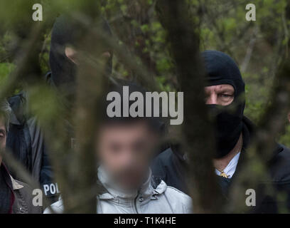 Wiesbaden, Deutschland. 27 Mär, 2019. Von zwei maskierten Polizisten begleitet, Ali B., warf der Ermordung der 14-jährige Susanna, ist entlang einer Bahnstrecke in der Nähe von Erbenheim geführt. Hier der Mann, der aus dem Irak stammen, angeblich das Mädchen vergewaltigt und dann getötet und begraben ihren Körper. Credit: Boris Roessler/dpa/Alamy leben Nachrichten Stockfoto